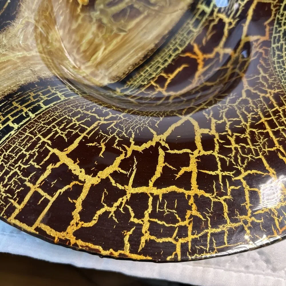 Glass bowl features an asymmetrical shape with a striking black and gold crackle